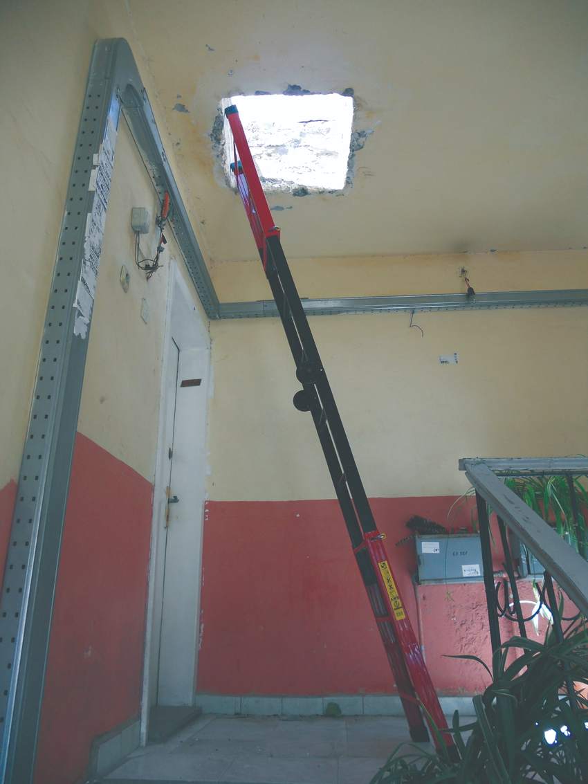 Stairwell with an opening cut through the ceiling to reach the roof